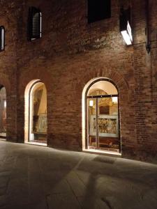 eine Backsteinmauer mit drei Fenstern in einem Gebäude in der Unterkunft Hotel Bel Soggiorno in San Gimignano