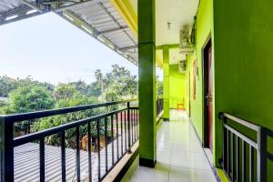 d'un balcon avec des murs verts et une balustrade noire. dans l'établissement OYO 92467 Cahyo Kost 1, à Semarang