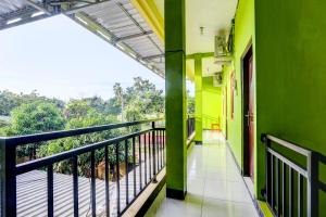 balcón con paredes verdes y barandilla negra en OYO 92467 Cahyo Kost 1, en Semarang