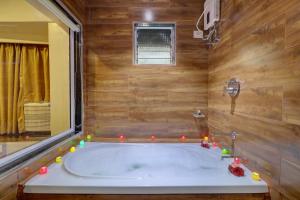 a bath tub with candles around it in a bathroom at Platinum Hotel in Turambhe