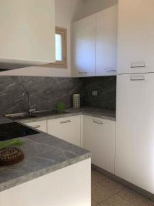 a kitchen with white cabinets and a white refrigerator at Holiday home in Bibione 41086 in Bibione