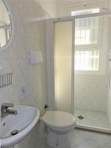 ein Bad mit einem Waschbecken, einem WC und einer Dusche in der Unterkunft Holiday home in Bibione 41086 in Bibione
