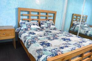 a bedroom with a bed with a quilt on it at Dream Village Boca Chica frente a la playa in Boca Chica