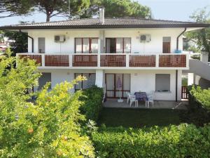 Casa blanca con balcón, mesa y sillas en Apartment in Bibione 38360, en Bibione