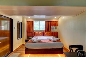 a bedroom with a large bed and a window at Platinum Hotel in Turambhe