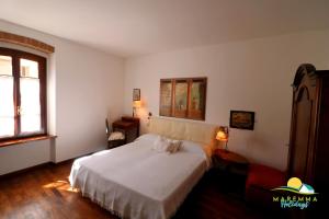 a bedroom with a white bed and a window at Maremma Holidays : Casa Lory in Massa Marittima