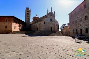 an old building with two towers in a courtyard at Maremma Holidays : Casa Lory in Massa Marittima