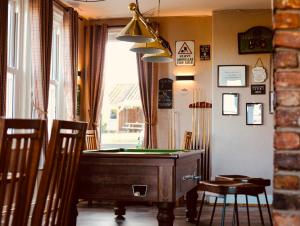 a room with a pool table and some chairs at The Ham and Cheese in Scagglethorpe
