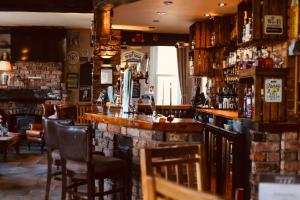 um bar num pub com cadeiras e um balcão em The Ham and Cheese em Scagglethorpe