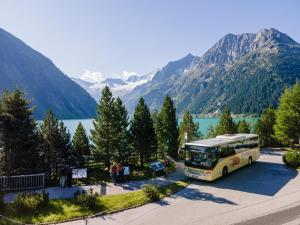 ein Bus parkt auf einem Parkplatz neben einem See in der Unterkunft Kallis Appartement in Mayrhofen