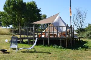 a tent on a dock with a chair and a grill at Camping La Petite Houmée in Curzay-sur-Vonne