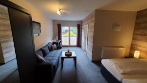 Zimmer mit Sofa, Bett und Tisch in der Unterkunft Spreewaldhof Romantik - Hotel Garni in Neu Zauche