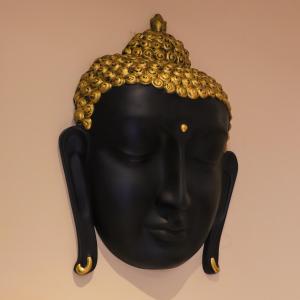 a bronze head with a crown on a wall at The Cape Grace Hotel in Jalandhar