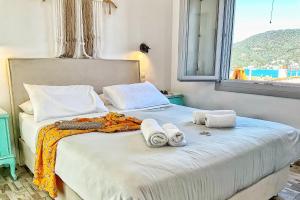 una camera da letto con un letto e asciugamani di Gigi Rooms a Poros