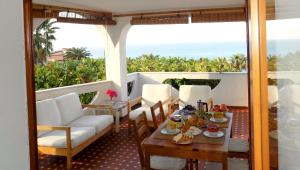 a balcony with a table and chairs and the ocean at Le Case di Concetta in Santa Maria