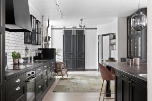 a kitchen with black cabinets and a sink at Villa S:t Hans in Visby