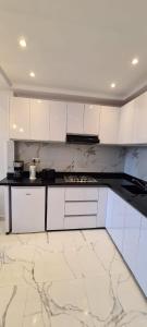 a kitchen with white cabinets and a marble floor at Luxueux Appartement DOWNTOWN RABAT in Rabat