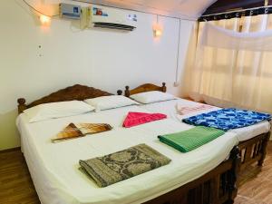 a bed with some towels on it in a room at Lacto Cressida Huts in Palolem