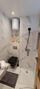 a bathroom with a black toilet and a shower at Luxueux Appartement DOWNTOWN RABAT in Rabat +14 photos