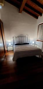 a bedroom with a large bed with two lamps at Casa Adige in Verona