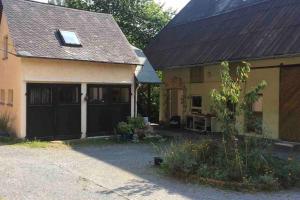 uma casa com uma garagem com uma porta de garagem preta em Kleine Kunstremise mit Holzofen Burg Freienfels em Weinbach