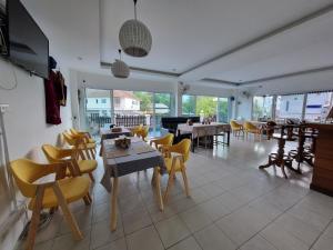 una sala da pranzo con tavoli, sedie e pianoforte di MM Hill Koh Samui Hotel - SHA Certified a Chaweng Beach