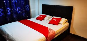 a bedroom with a bed with two red pillows at 1st Inn Hotel Klang Sentral Meru in Klang