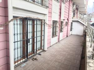 a corridor of a pink building with bars on the doors at location İstanbul in Istanbul