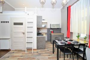 kuchnia i jadalnia ze stołem i krzesłami w obiekcie Apartamenty Jozefa Kazimierz w Krakowie