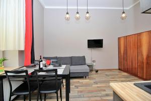 a living room with a table and chairs and a couch at Apartamenty Jozefa Kazimierz in Krakow