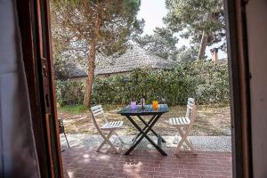 a table with chairs and a table with drinks on it at Apartment in Rosolina Mare 43995 in Rosolina Mare