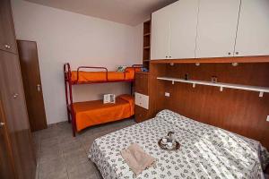 a bedroom with a bed and two bunk beds at Apartment in Rosolina Mare 43995 in Rosolina Mare