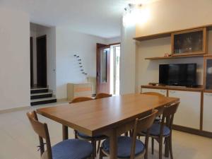 a dining room with a wooden table and chairs at Holiday home in Bibione 36470 in Bibione