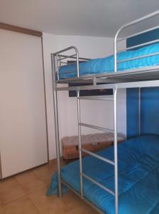 um quarto com 2 beliches com lençóis azuis em Appartement à 100m de la plage 7 nuits minimum haute saison em Sainte-Maxime