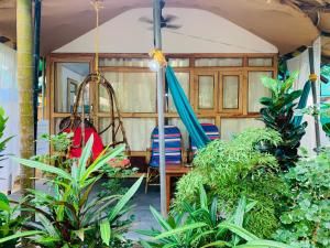 a swing and a hammock in a room with plants at Lacto Cressida Huts in Palolem