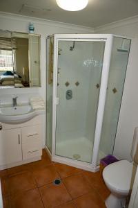 a bathroom with a shower and a toilet and a sink at City/Valley Resort Apartment in Brisbane