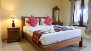 Un dormitorio con una cama con toallas. en Buana Ubud Inn, en Ubud