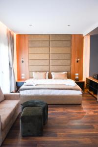 ein Schlafzimmer mit einem großen Bett und einem Sofa in der Unterkunft Olivia's Hill Resort in Durrës
