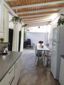 a kitchen with a table and a white refrigerator at Vila Marius 2 Mai in 2 Mai