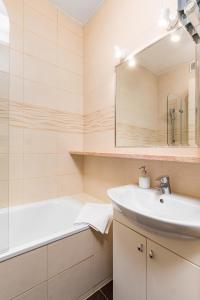 a bathroom with a sink and a tub and a mirror at Apartament Mariensztat by Your Freedom in Warsaw