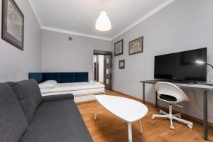 a living room with a couch and a table and a tv at Apartament Mariensztat by Your Freedom in Warsaw