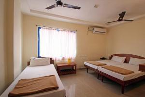 1 Schlafzimmer mit 2 Betten und einem Fenster in der Unterkunft Bhanu Residency in Tirupati