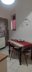 a table in a kitchen with a red cloth on it at Estía Holidays Apartments - Taormina in Taormina