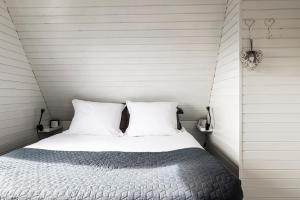 a bedroom with a bed with two white pillows at Strandhuis de Zeeparel met hottub in Petten