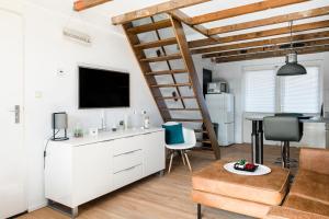 a living room with a loft bed and a desk at Strandhuis de Zeeparel met hottub in Petten