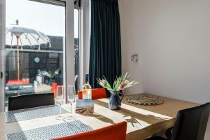 a dining room table with a laptop on top of it at Strandhuis de Zeeparel met hottub in Petten