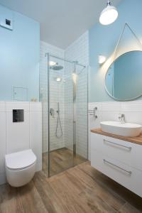 a bathroom with a shower and a toilet and a sink at Apartament Olimpijska z ogródkiem i widokiem na jezioro in Olsztyn