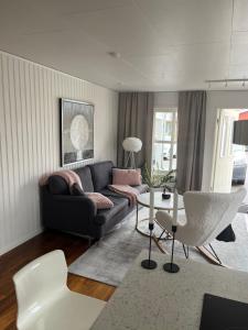 uma sala de estar com um sofá e uma mesa em Nära till allt em Falkenberg