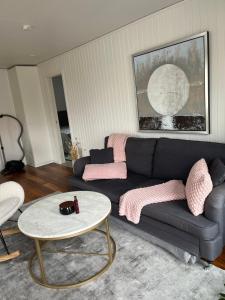 uma sala de estar com um sofá e uma mesa em Nära till allt em Falkenberg mais 1 fotografia