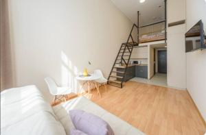 ein Wohnzimmer mit einem Bett und einer Treppe in einem Zimmer in der Unterkunft Smart House 7 in Kiew